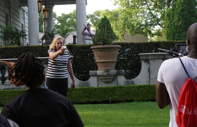 A couple draws their firearms on protesters as they enter their neighborhood during a protest against St. Louis Mayor Lyda Krewson, in St. Louis, Missouri. REUTERS/Lawrence Bryant